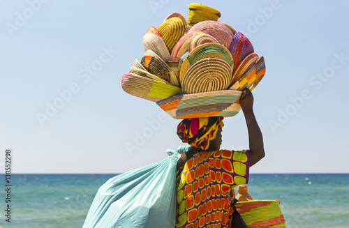 Photos donna africana immigrata che vende cestini in Italia lungo la spiaggia