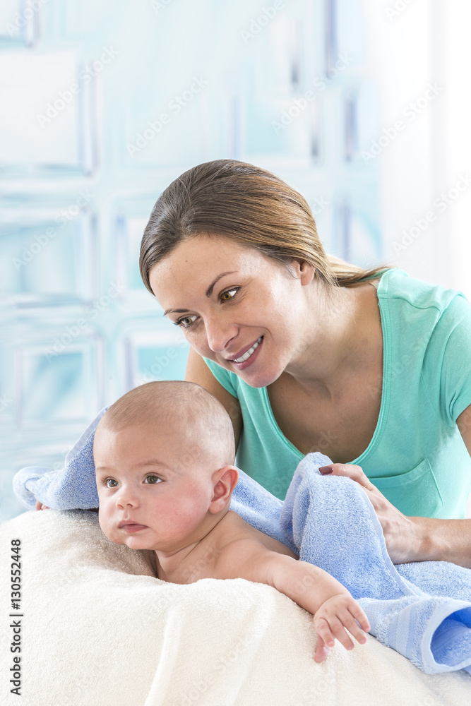 happy mother is drying her baby boy after bathing