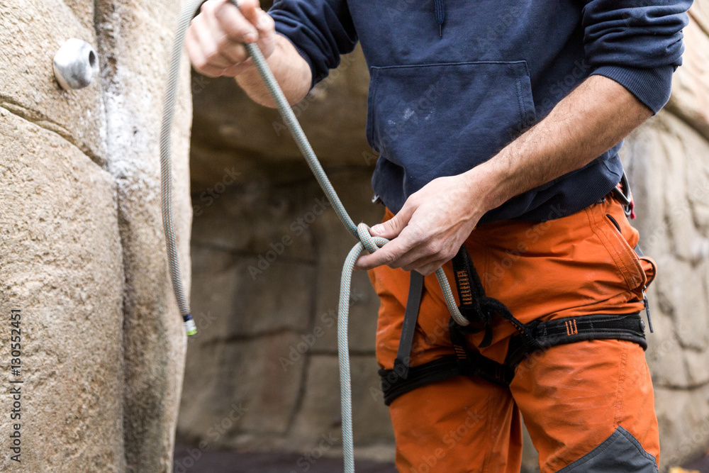 Young man preparing the equipment for climbing. Young man preparing the equipment for climbing.