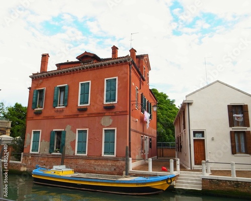 VENICE, ITALY - MAY 27, 2015 : street view of a boat on Venice's canal in the old city center of Venice.