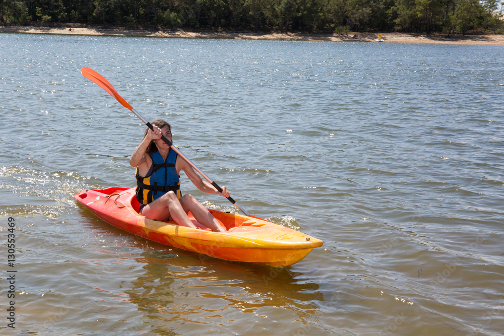 fit woman in kayak for holidays, vacation on mountain lake or river