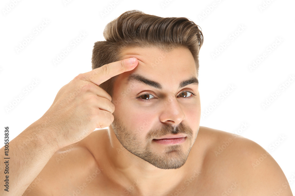 Young handsome man examining his face on white background Young handsome man examining his face on white background