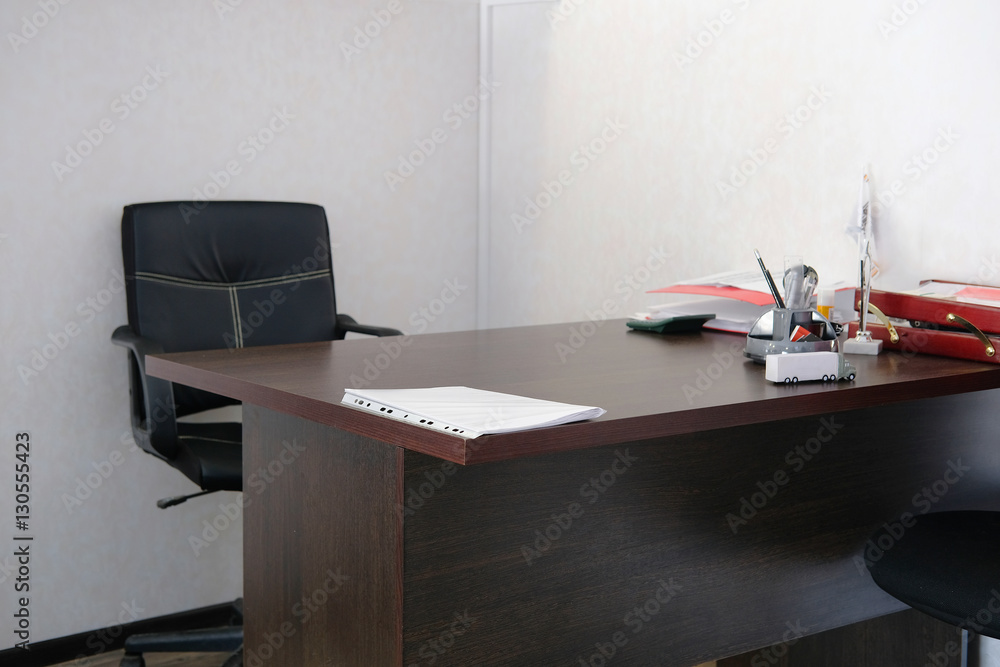 Interior of an office room with chair, table and stationery on it Interior of an office room with chair, table and stationery on it
