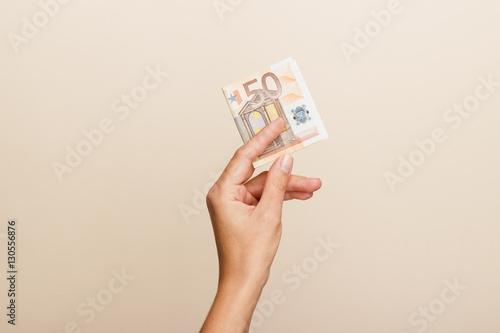 Woman's hand with money on a light background