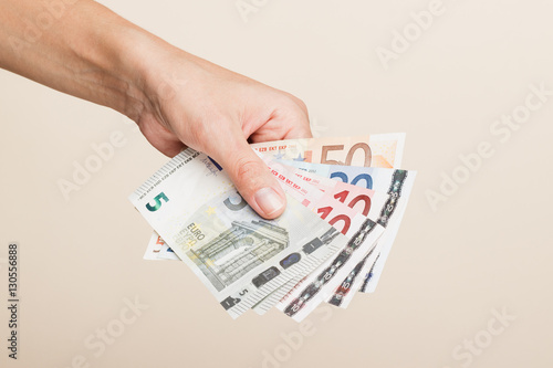 Woman's hand with money on a light background