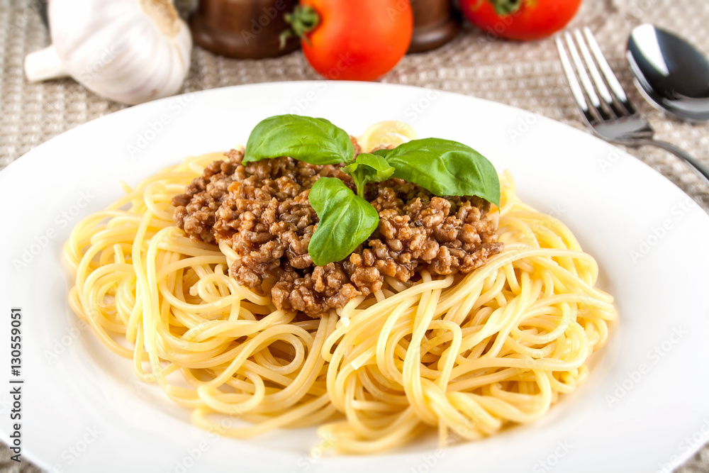Spaghetti bolognese with basil on white plate