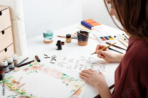 Girl writing calligraphy on postcards. Art design. photo