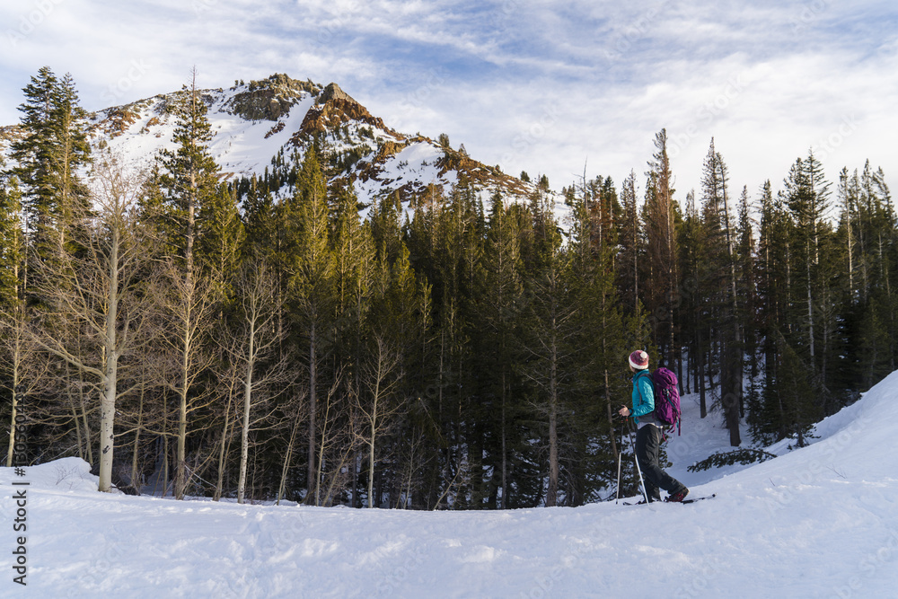 Woman with ski poles walking on snowy field Woman with ski poles walking on snowy field
