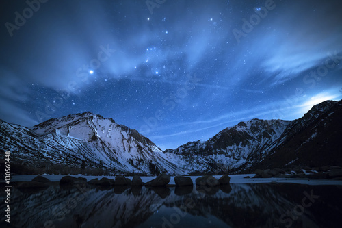 Scenic view of snow covered mountain against starry sky photo