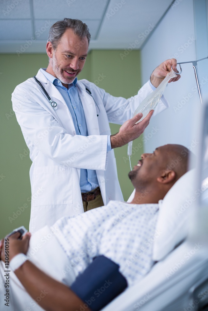 © WavebreakMediaMicro - Doctor interacting with patient while adjusting iv drip
