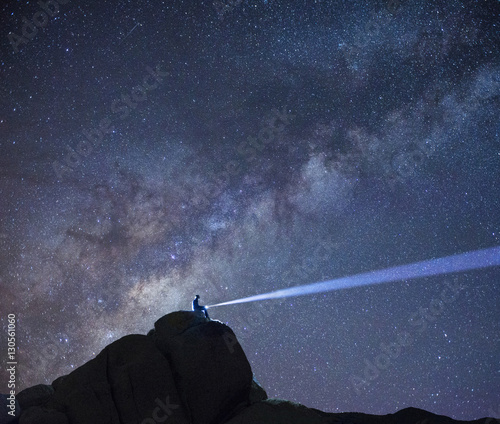 Scenic view of hiker with illuminated torch against starry sky