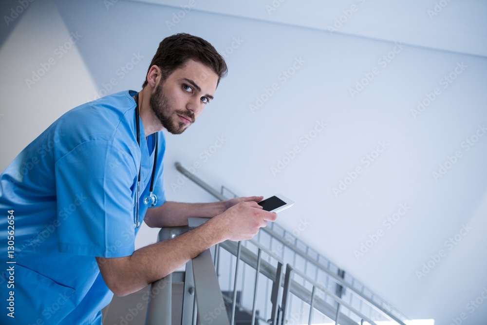 Portrait of male nurse using digital tablet in corridor Portrait of male nurse using digital tablet in corridor
