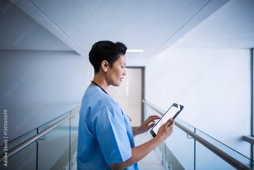 © WavebreakMediaMicro - Female nurse using digital tablet in corridor © WavebreakMediaMicro - Female nurse using digital tablet in corridor