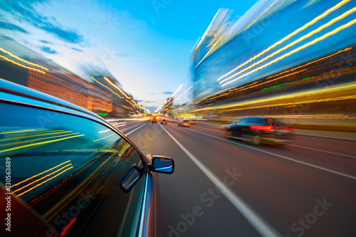 Fast Driving Car Through the City. Long Exposure Photography. Speeding Car Motion Blur