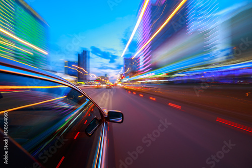 The car moves at fast speed at the night. Blured road with lights with car on high speed.