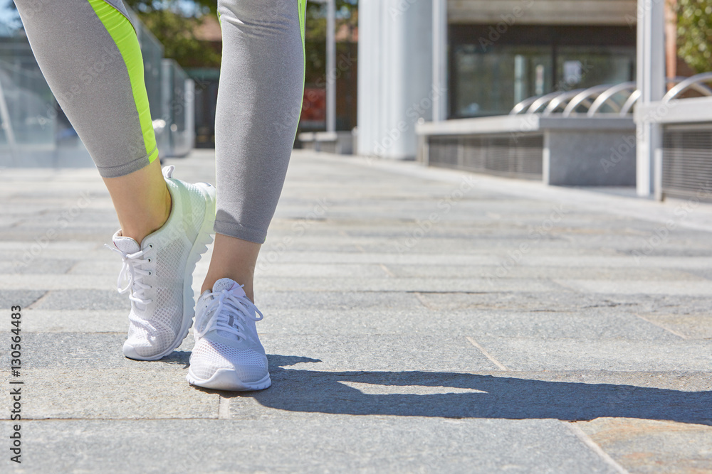 Woman with white sport shoes ready to run outdoor in the city