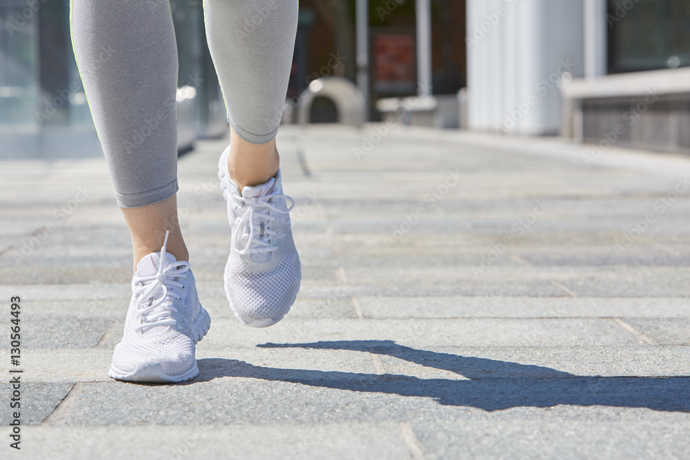 Woman running outdoor in the city in summer