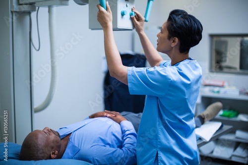 Tableau sur toile Female doctor sets up the machine to x-ray