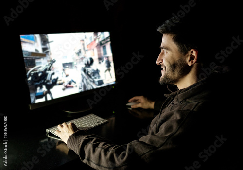 Happy man playing videogame on desktop computer