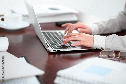 Close up of business woman hands typing on laptop computer