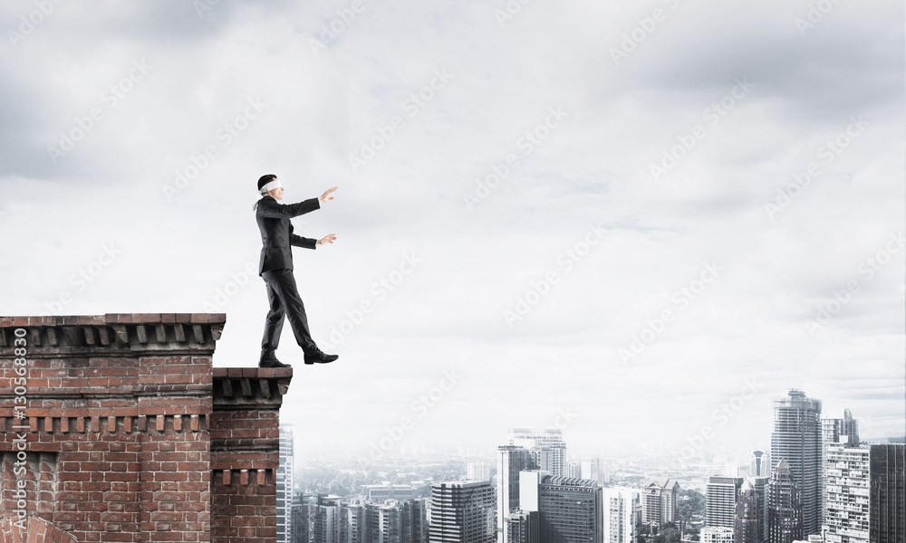 Danger and risk concept with businessman making step from edge Danger and risk concept with businessman making step from edge