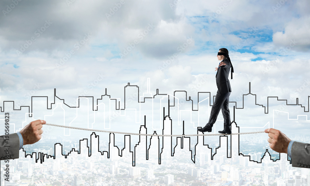 Business concept of risk support and assistance with man balancing on rope Business concept of risk support and assistance with man balancing on rope