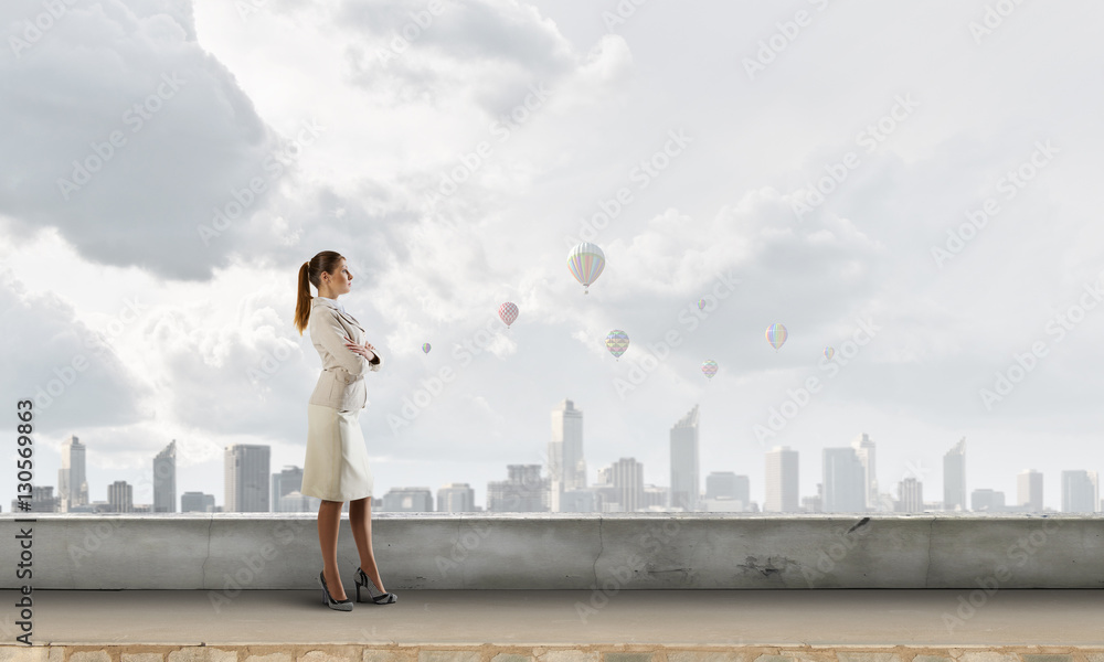 Businesswoman on building roof . Mixed media Businesswoman on building roof . Mixed media