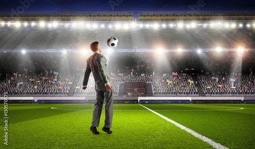 Businessman playing soccer . Mixed media © Sergey Nivens