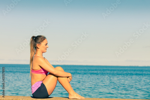 Woman doing sports exercises outdoors by seaside