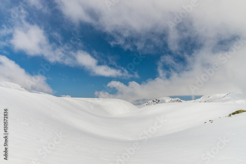 Snow hills against clear blue sky © NAVAPON