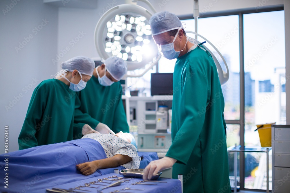 Surgeons performing operation in operation room Surgeons performing operation in operation room
