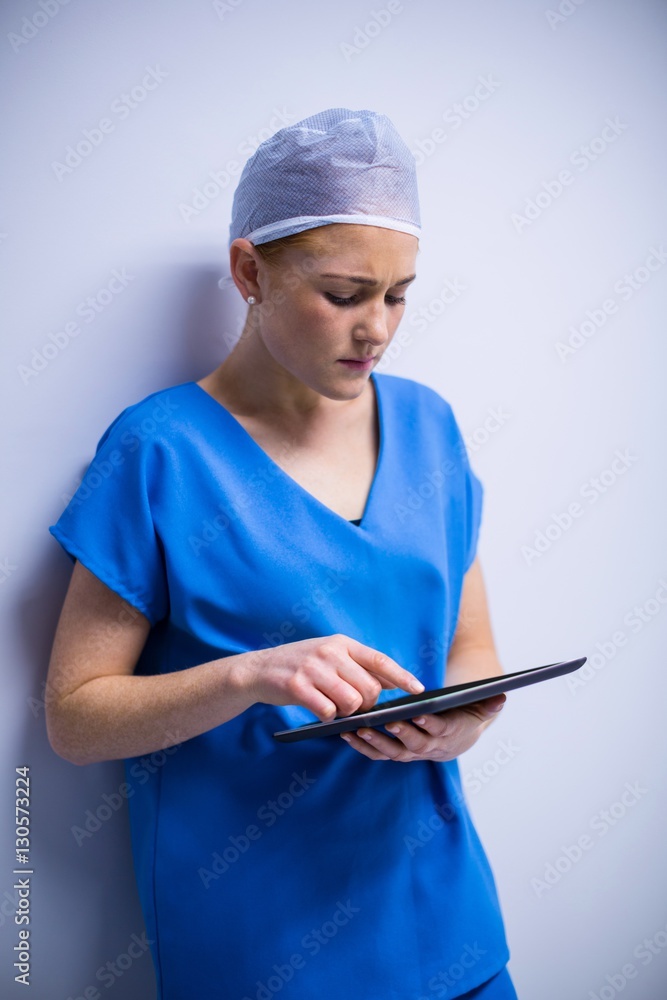 Female nurse using digital tablet in corridor Female nurse using digital tablet in corridor