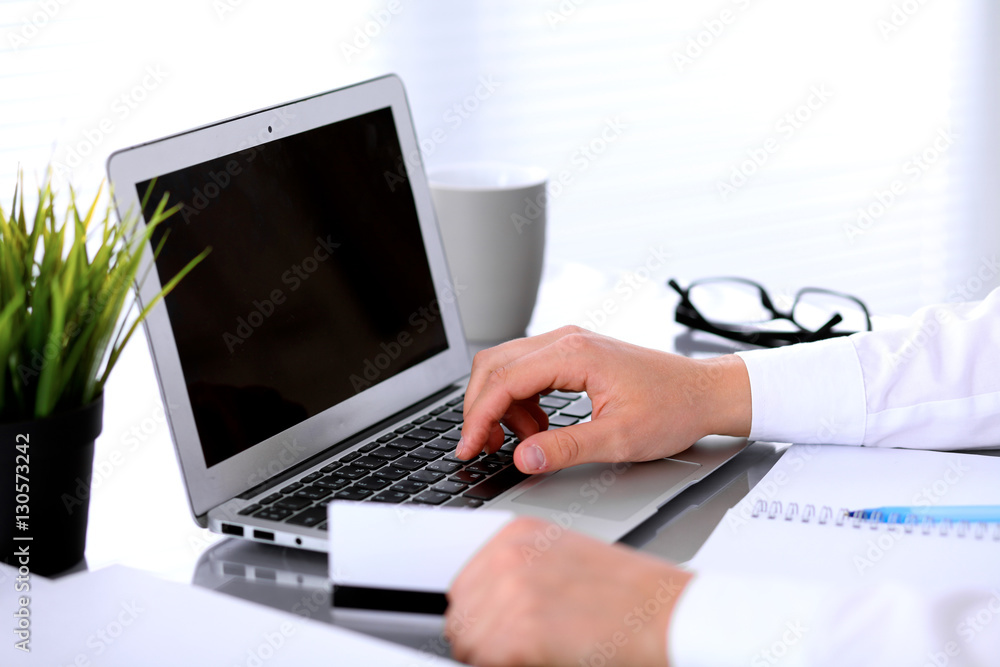 Close up of business woman hands using credit card and laptop computer Close up of business woman hands using credit card and laptop computer