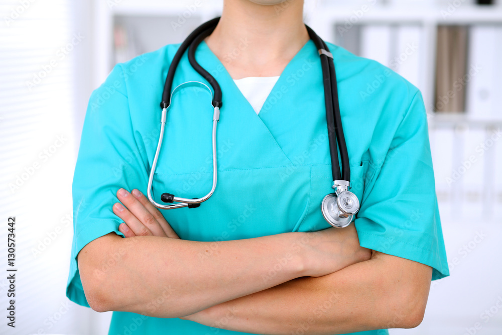 Female surgeon doctor is standing with arms crossed at hospital. Physician is ready to examine patient Female surgeon doctor is standing with arms crossed at hospital. Physician is ready to examine patient