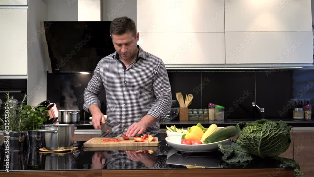 Young man cutting pepper, smiles to camera. Slider shot.
Young man cutting pepper, smiles to camera. Slider shot.