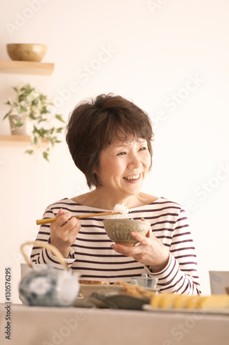 和食を食べるシニア女性
