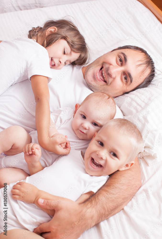 Portrait of a father with children on the bed Portrait of a father with children on the bed