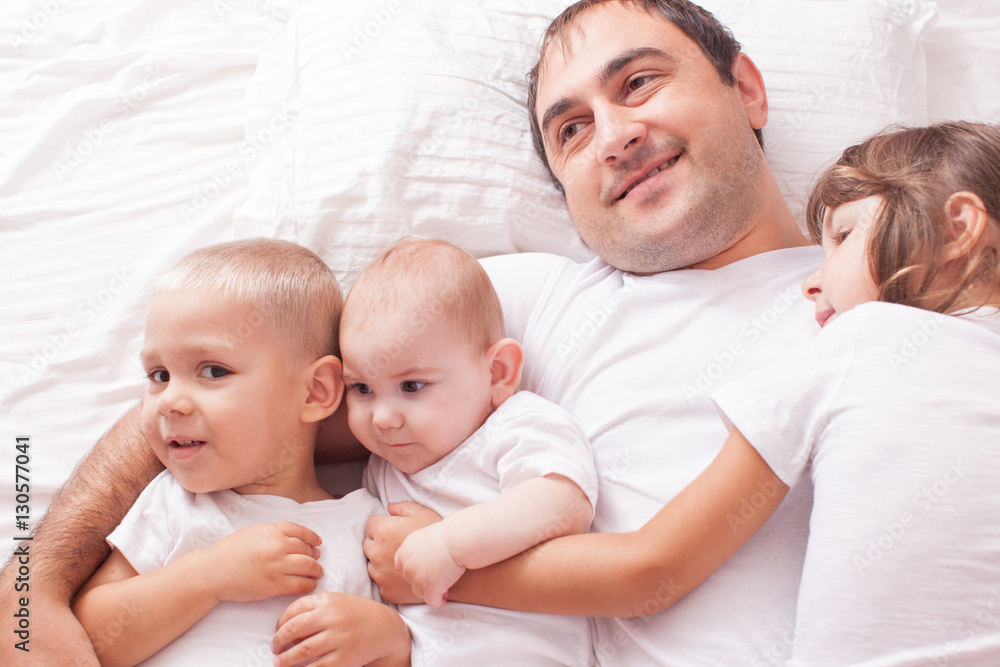 Portrait of a father with children on the bed Portrait of a father with children on the bed
