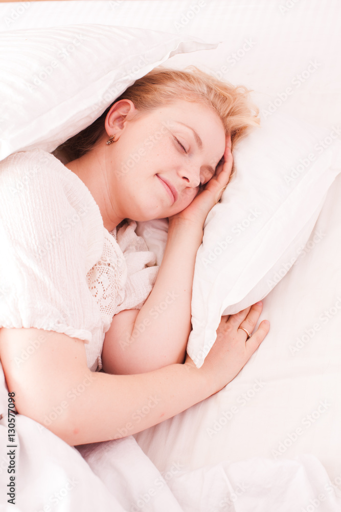 Woman sleeping in white bed