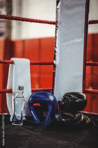 Boxing gloves, headgear, water bottle and a towel in boxing ring