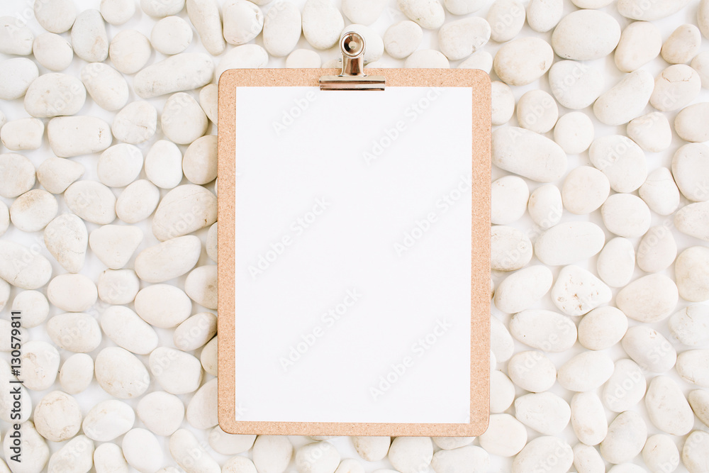 Clipboard on neutral pattern of beige stones. Flat lay, top view Clipboard on neutral pattern of beige stones. Flat lay, top view