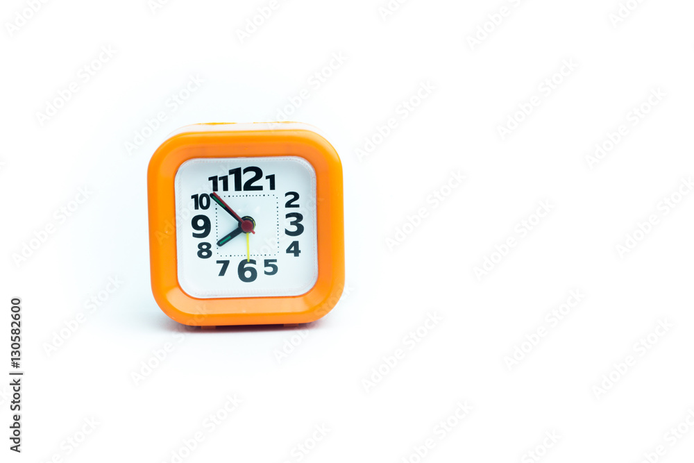 Clock orange with white backdrop..Orange clock on a white backgr Clock orange with white backdrop..Orange clock on a white backgr