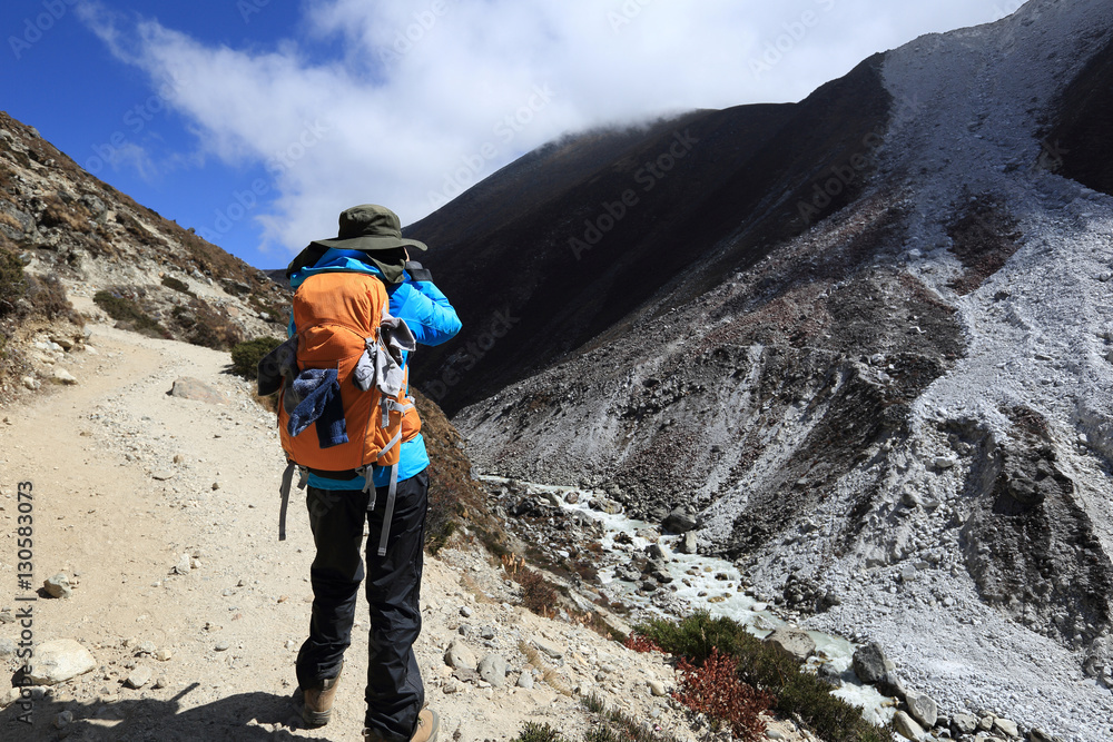 woman backpacker taking photo while trekking at the himalaya mountains