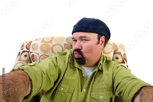 Fotografi Man in armchair blowing kiss and taking selfie