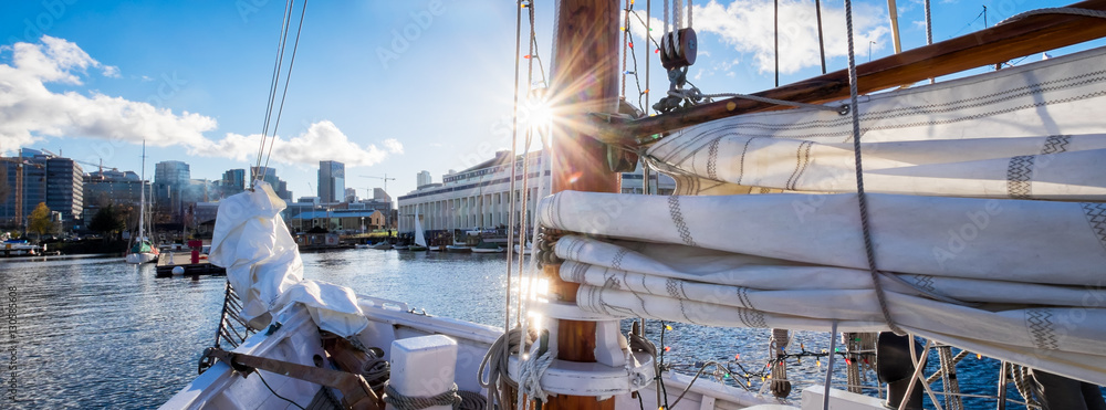 Naklejka premium Seattle sailing on Lake Union in a vintage yacht sailboat. Sun flare on mast