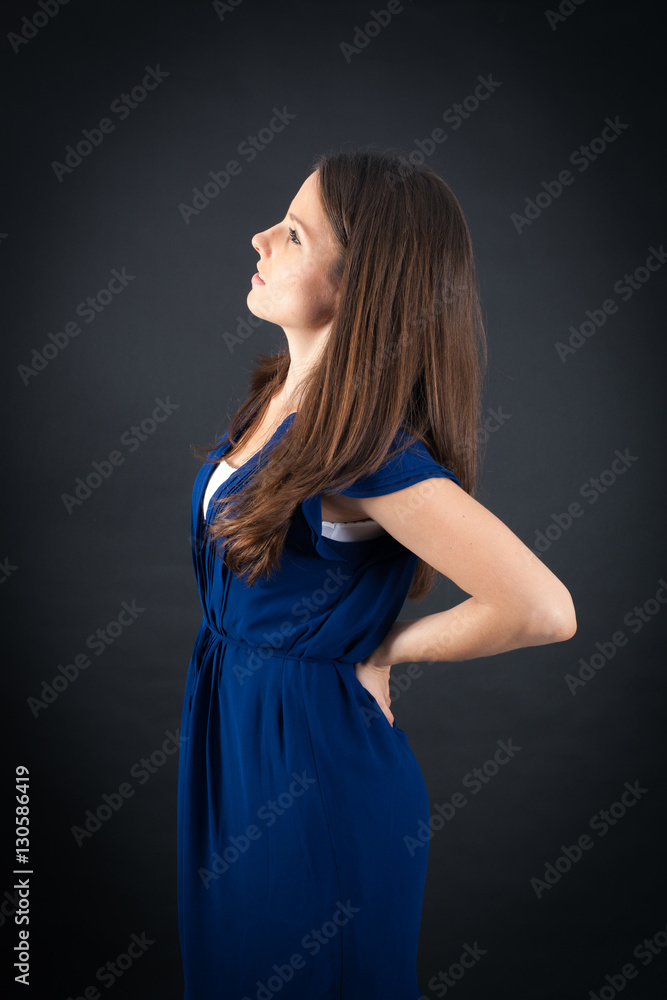 Beautiful woman doing different expressions in different sets of clothes: backache Beautiful woman doing different expressions in different sets of clothes: backache