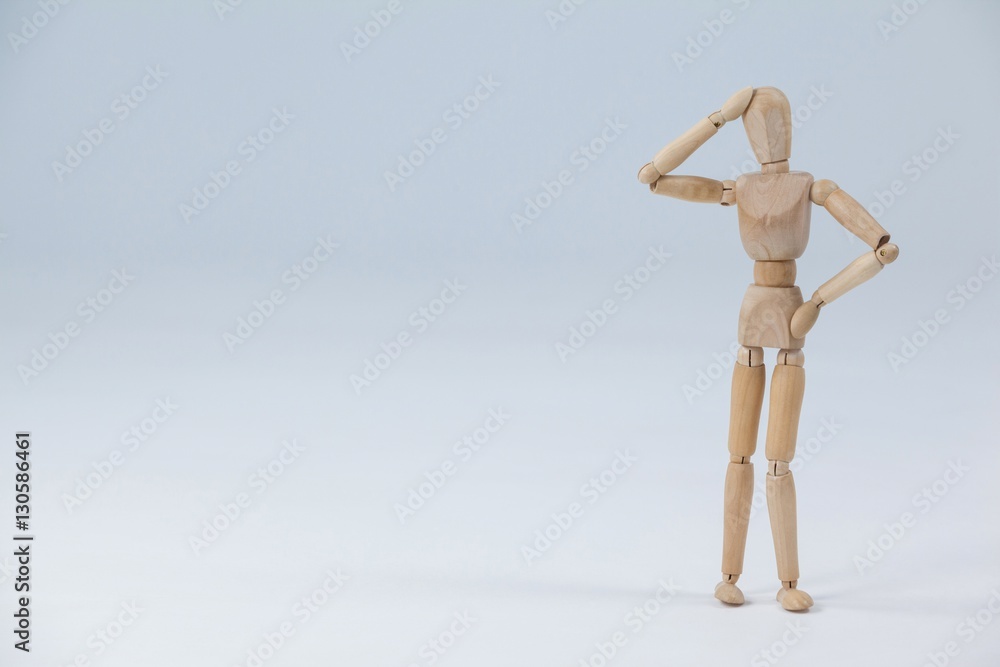Confused wooden figurine standing with hand on head Confused wooden figurine standing with hand on head
