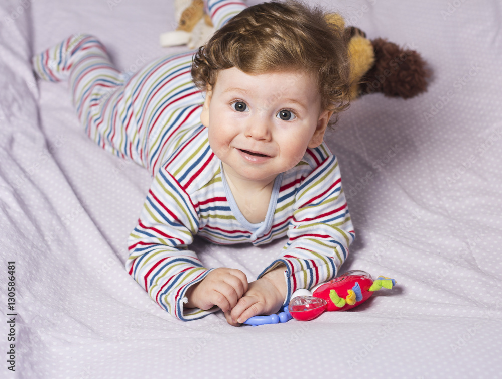 The little boy in the crib with toys. The child in the home
The little boy in the crib with toys. The child in the home