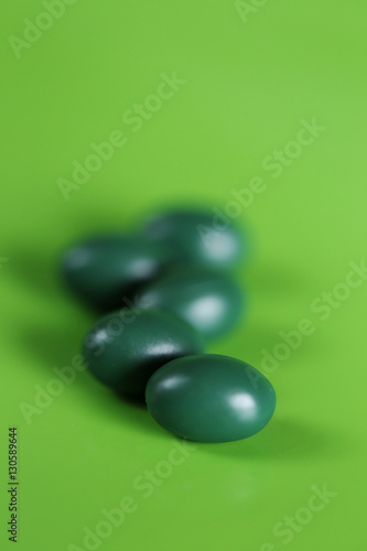 dark green capsule on green background 1