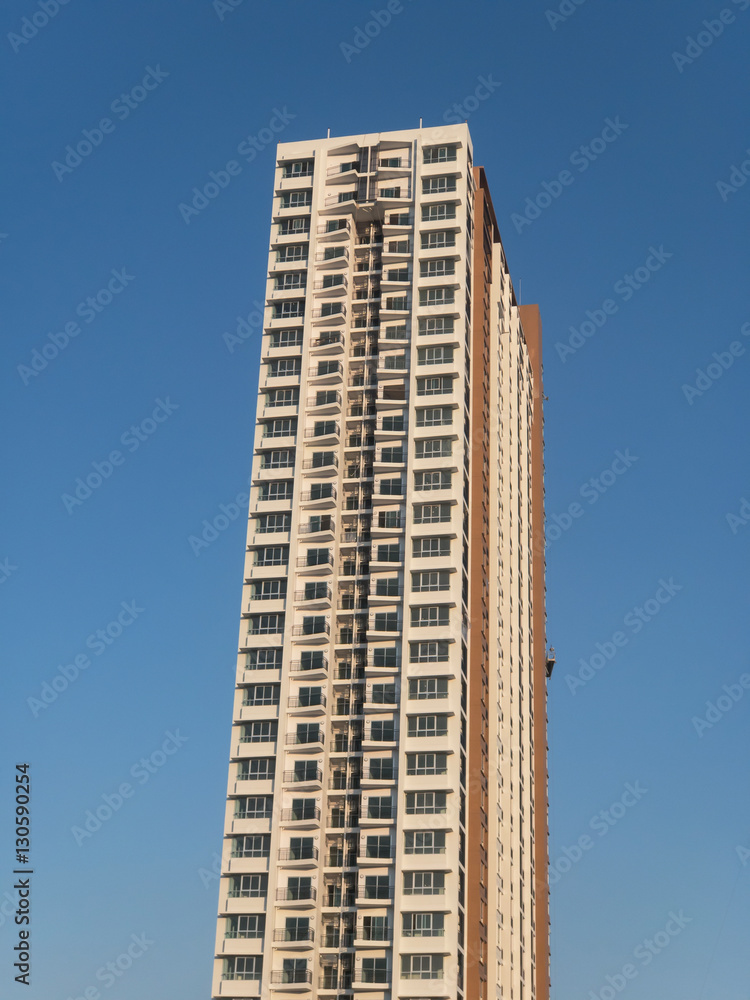Fototapeta premium Single high building condominium with blue sky background